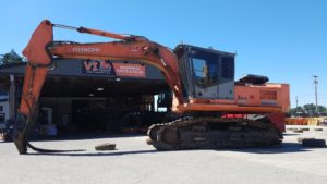 an orange excavator in front of a building